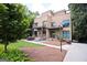 Modern two-story home with balconies, red entry door, manicured lawn, mature trees, and lush shrubbery at 870 Monroe Ne Dr, Atlanta, GA 30308