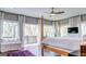 Bright main bedroom boasts hardwood floors, a ceiling fan, and large windows overlooking a private balcony and wooded view at 870 Monroe Ne Dr, Atlanta, GA 30308