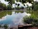 Scenic view of a pond reflecting the sky and downtown skyline, surrounded by lush greenery and mature trees at 870 Monroe Ne Dr, Atlanta, GA 30308