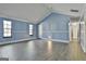 Inviting living room with paneled light blue walls, wood-look floors, and a vaulted ceiling at 6187 Radford Dr, Riverdale, GA 30296