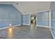 Bright living room featuring light blue walls, white trim, and wood-look flooring at 6187 Radford Dr, Riverdale, GA 30296