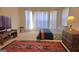 Bright bedroom featuring a bed with many windows, a colorful rug, and a wooden desk at 35 Abelia Dr, Covington, GA 30014
