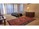 Bright bedroom featuring a bed with many windows, a colorful rug, and a wooden desk at 35 Abelia Dr, Covington, GA 30014