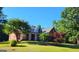 Traditional brick home featuring a manicured lawn, mature landscaping, and a welcoming front porch at 35 Abelia Dr, Covington, GA 30014