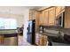 Open kitchen featuring stainless appliances, wooden cabinetry and dark countertops at 35 Abelia Dr, Covington, GA 30014