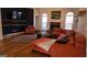 Spacious living room with dark accent wall, hardwood floors, a brick fireplace, and arched windows at 35 Abelia Dr, Covington, GA 30014