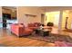 Spacious living room featuring hardwood floors, a comfortable sectional sofa, and natural light at 35 Abelia Dr, Covington, GA 30014