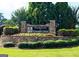 Beautifully landscaped community entrance sign at The Estates at Persimmon Creek with vibrant flowers at 44 Willow Leaf Way, Sharpsburg, GA 30277
