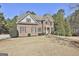 Attractive brick home with mature trees, symmetrical windows, and a bright green front door at 44 Willow Leaf Way, Sharpsburg, GA 30277