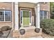 Inviting front entrance with a bright green door, brick steps, and manicured bushes at 44 Willow Leaf Way, Sharpsburg, GA 30277