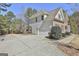 Side-angle view of a home, focusing on its three-car garage and driveway at 44 Willow Leaf Way, Sharpsburg, GA 30277