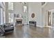 Open-concept living room with tall ceilings, fireplace, large windows, and hardwood floors at 44 Willow Leaf Way, Sharpsburg, GA 30277
