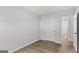 An empty bedroom with wood-look flooring features neutral walls and interior doors at 7236 Crestside Dr # 80, Austell, GA 30168
