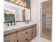 Stylish bathroom featuring a double sink vanity, modern mirrors, and a view into the closet at 201 Lanyard Loop, Peachtree City, GA 30269