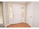 Bright foyer with a decorative front door featuring sidelights, hardwood floors, and neutral walls at 201 Lanyard Loop, Peachtree City, GA 30269