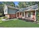 Charming brick home with a welcoming front porch, classic white columns, and a lush green lawn and beautiful front garden at 201 Lanyard Loop, Peachtree City, GA 30269