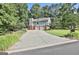 Spacious two-car garage with a long driveway, light blue siding, brick facade, and well-maintained yard at 201 Lanyard Loop, Peachtree City, GA 30269