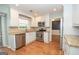 Bright kitchen featuring stainless steel appliances, granite countertops, and white cabinetry with hardwood floors at 201 Lanyard Loop, Peachtree City, GA 30269