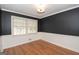 Versatile room with hardwood floors, neutral walls, and a large window, perfect for an office, playroom, or guest bedroom at 201 Lanyard Loop, Peachtree City, GA 30269