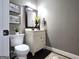 Stylish half-bathroom with a framed mirror, a white vanity, and elegant fixtures at 34 Brittany Way, Palmetto, GA 30268