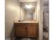 Bathroom featuring wood cabinet, light countertop, large mirror, and tiled floor at 34 Brittany Way, Palmetto, GA 30268