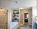 Bathroom featuring a soaking tub, shelves with decor, and access to the ensuite bedroom at 34 Brittany Way, Palmetto, GA 30268