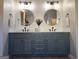 Bathroom with double vanity, shiplap accent wall, granite countertop, matte black fixtures, and round mirrors at 34 Brittany Way, Palmetto, GA 30268