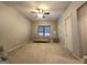Bedroom featuring neutral carpet, ceiling fan, a single window, and white door at 34 Brittany Way, Palmetto, GA 30268