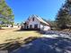 Exterior angle view showing the two-car garage, set on a sunny day with well-maintained landscaping at 34 Brittany Way, Palmetto, GA 30268