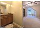 Bathroom featuring wooden cabinet and view through to carpeted bedroom beyond at 34 Brittany Way, Palmetto, GA 30268