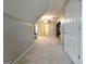 Carpeted hallway with sofa to the left and custom built-in shelving and TV to the right at 34 Brittany Way, Palmetto, GA 30268