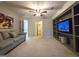 Spacious carpeted living room with grey sofa and custom built-in shelving unit with TV at 34 Brittany Way, Palmetto, GA 30268