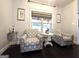 Cozy sitting area with patterned chairs and natural light filtering through a window with blinds at 34 Brittany Way, Palmetto, GA 30268