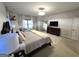 Bright main bedroom features a dresser, large mirror, TV, sitting chairs, and a king-size bed at 34 Brittany Way, Palmetto, GA 30268