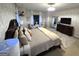 Bright main bedroom features a dresser, large mirror, TV, sitting chairs, and a king-size bed at 34 Brittany Way, Palmetto, GA 30268