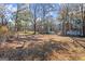 Expansive backyard featuring mature trees and outbuildings for storage or hobbies at 5211 Old Monticello Se St, Covington, GA 30014