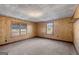 Bedroom featuring wood-look wall paneling, and plush carpeting with natural light at 5211 Old Monticello Se St, Covington, GA 30014