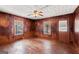 Cozy living room featuring wood paneling, ceiling fan, and natural light from the windows at 5211 Old Monticello Se St, Covington, GA 30014