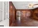 Living room features wood-paneled walls, tiled flooring, a ceiling fan, and a doorway at 5211 Old Monticello Se St, Covington, GA 30014