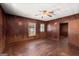 Living room with wood-paneled walls, tiled flooring, a ceiling fan, and natural light at 5211 Old Monticello Se St, Covington, GA 30014