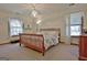 Sun-filled bedroom with a sleigh bed, two windows, and neutral carpet at 300 Planceer Pl, Peachtree City, GA 30269