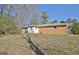 Rear view of house with a white back door that leads to a lawn and mature trees at 940 New Hope Rd, Fayetteville, GA 30214