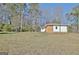 The backyard features a playset and a brick home with a white trim, set on a gently sloping lawn at 940 New Hope Rd, Fayetteville, GA 30214