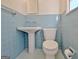 Retro bathroom featuring light blue tile, a pedestal sink, and a toilet with a matching blue seat at 940 New Hope Rd, Fayetteville, GA 30214