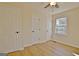 Bedroom featuring wood floors, a window, ceiling fan, and two white doors at 940 New Hope Rd, Fayetteville, GA 30214