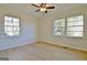 Well-lit bedroom with wood floors, a ceiling fan, and two windows providing ample natural light at 940 New Hope Rd, Fayetteville, GA 30214
