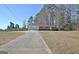 Spacious home with a long driveway winding through a lush, wooded landscape at 940 New Hope Rd, Fayetteville, GA 30214