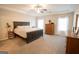 Large main bedroom featuring neutral walls, carpet, and a tray ceiling with a fan at 337 Paynes Lake Rd, Carrollton, GA 30116