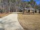 Long concrete driveway leading to a brick house, surrounded by mature trees and landscaping at 170 Royal Ridge Way, Fayetteville, GA 30215