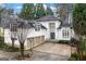 Elegant stucco home with three-car garage and double-door entry, surrounded by mature trees at 4000 Wieuca Rd Ne, Atlanta, GA 30342